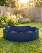 Empty blue foldable dog paddling pool set up on a lush green UK garden lawn