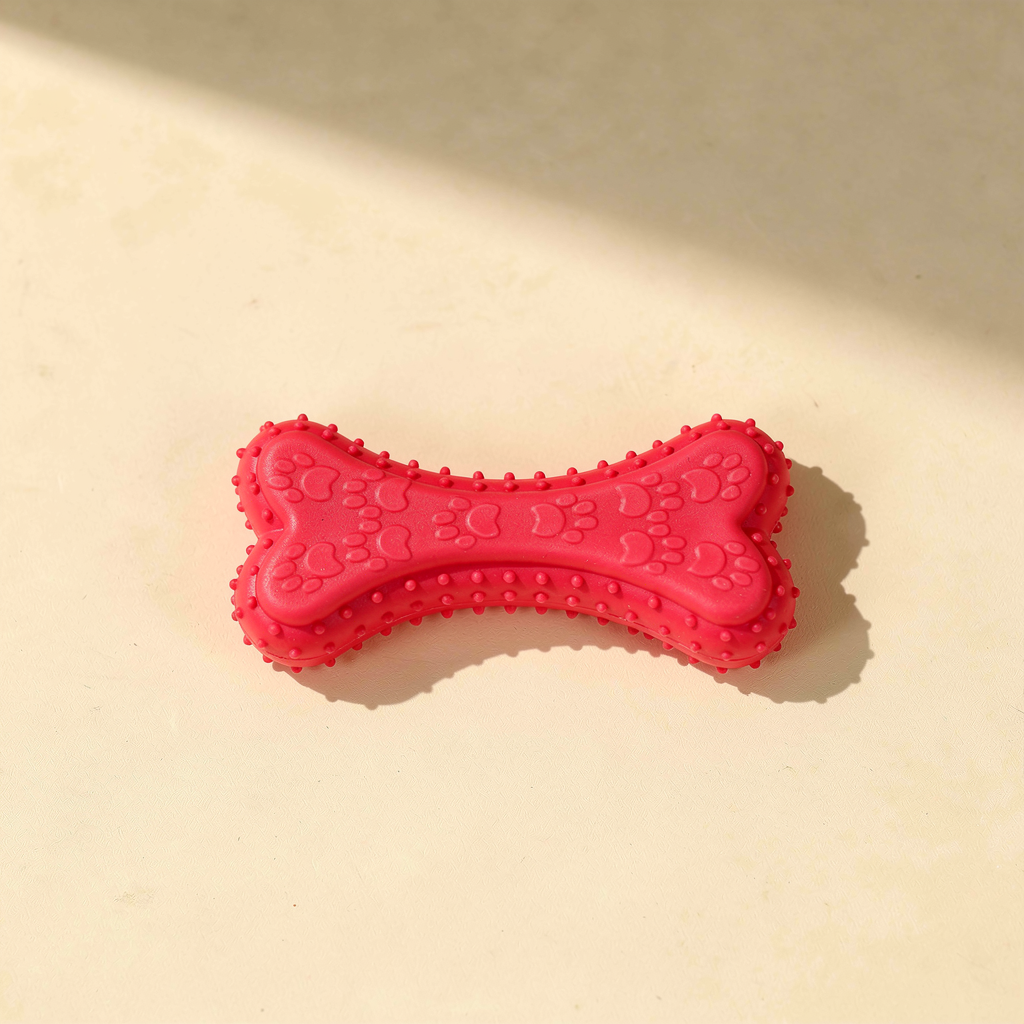 Buddies bite-resistant TPR dog chew bone in rose red / magenta pink. Same chunky paw-print pattern.